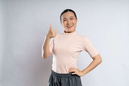 Asian woman happy confident smiling, looking at camera, standing isolated on white background.の写真素材