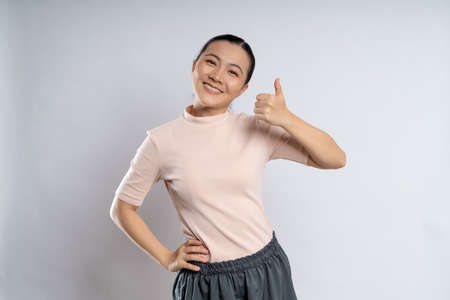Asian woman happy confident smiling, looking at camera, standing isolated on white background.の写真素材