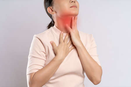 Asian woman was sick with toothache touching her cheek with red point and standing isolated on white background.の写真素材