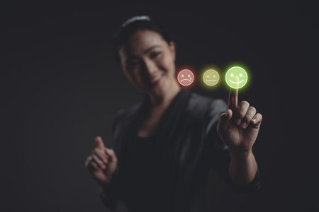 Asian woman voting and pressing angry face emoticon on virtual touch screen, isolated on background. Customer service satisfaction survey concept.の写真素材