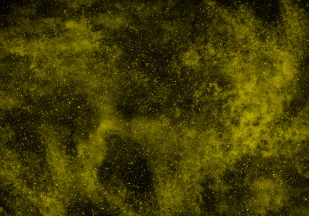 Abstract yellow powder explosion on black background. Yellow powder cloud texture.の写真素材