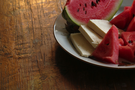 watermelon slices and cheese on wooden tableの写真素材