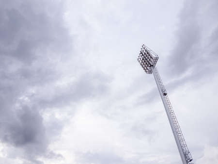 Single tall pillar of spotlights is surrounded by white and cloudy sky.の写真素材