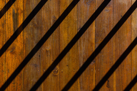 Closeup top view of shadow strips that are look like iron bar of prison cell lean across the floor...