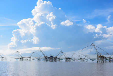Thailand southern local fishing tool called 'Yor' located in Thale Noi, Phatthalung, Thailand with beautiful blue sky and white cloudの写真素材