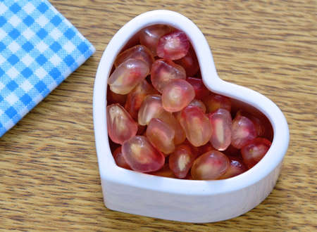 Pomegranate seeds on the hart cupの写真素材