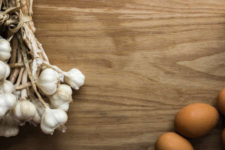 Garlic cloves and eggs on wooden vintage background.の写真素材