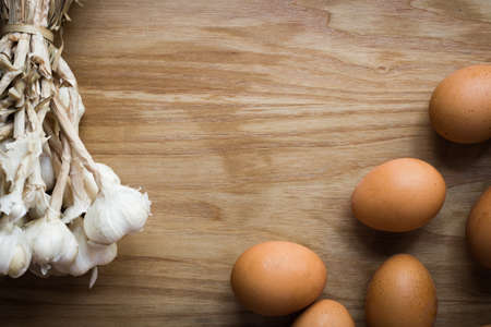 Garlic cloves and eggs on wooden vintage background.の写真素材