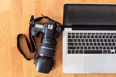 Working table with computer laptop, digital camera and copy space on wood desk background, Top view style, Minimal workspace, business Conceptの写真素材