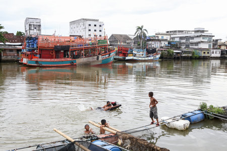 Pattani, Thailand - June 22, 2019, Many Asian children play in the water by the river.のeditorial素材