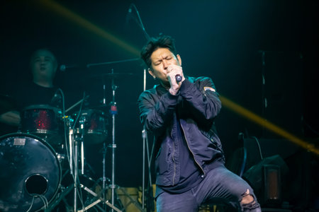 Asian singer and drummer of rock band musicians perform in concert on stageのeditorial素材