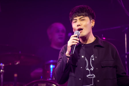 Asian singer and drummer of rock band musicians perform in concert on stageのeditorial素材