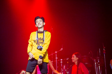 Asian men dancers wearing yellow shirts danced on the concert stage.のeditorial素材