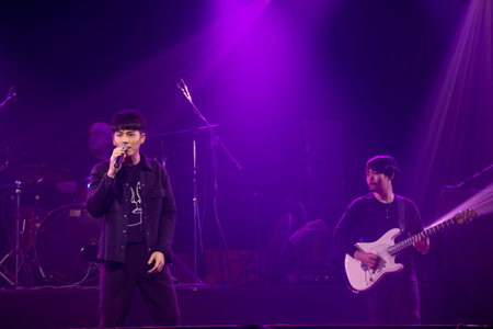 Asian singer, drummer and guitarist of rock band musicians perform in concert on stageのeditorial素材
