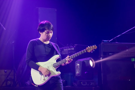 Asian guitarist of rock band musicians perform in concert on stageのeditorial素材