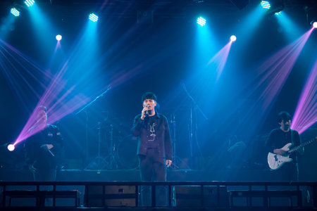 Asian singer, drummer and guitarist of rock band musicians perform in concert on stageのeditorial素材