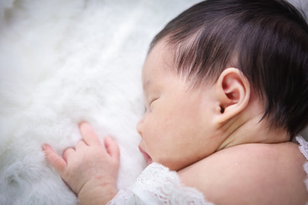 Asian beautiful newborn baby in white dress was sleeping on a white soft blanket, Infant, babyhood concept and copy space - Imageの写真素材