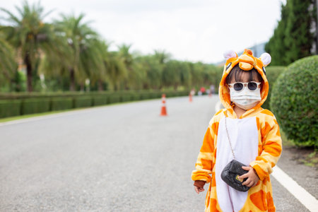 A cute Asian girl wearing a giraffe costume travel in a new normal state with a face mask.