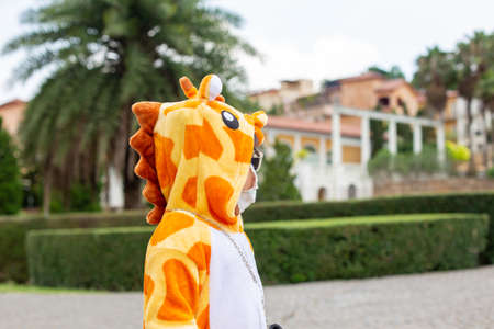 A cute Asian girl wearing a giraffe costume, Sunglasses travel in a new normal state with a face mask.の写真素材