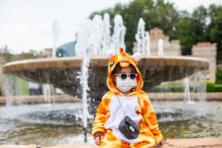 A cute Asian girl wearing a giraffe costume, Sunglasses travel in a new normal state with a face mask.の写真素材