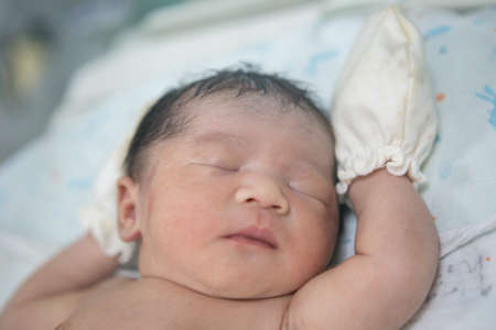 Close up of Asian newborn baby in the delivery room at hospital. In the newborn incubator is A medical device used to regulate the temperature of a newborn baby to be healthy according to the criteriaの写真素材