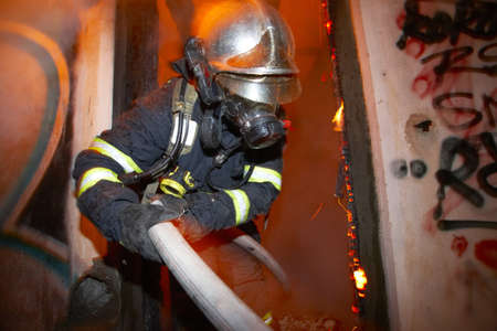 Fireman extinguishing fire inside an old houseのeditorial素材