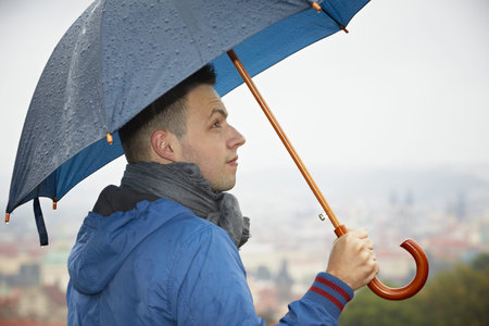 Rainy day in Prague - young man with umbrella の写真素材