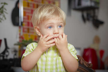 Surprised boy in the kitchenの写真素材