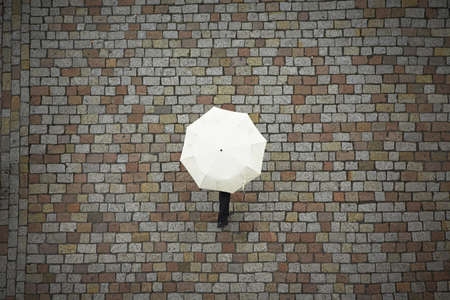 Man with white umbrella in rain の写真素材