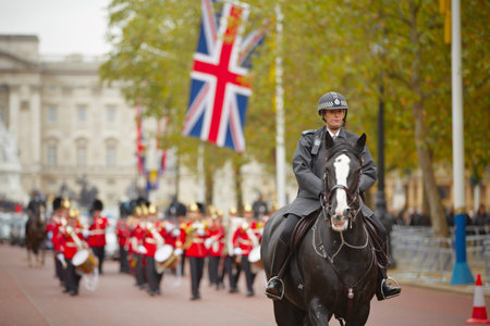 Policewoman on the horse behind marching the Queen's Guards during traditional Changing of the Guards ceremony at Buckingham Palace on October 25, 2012 in London, United Kingdom. のeditorial素材