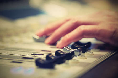 Professional audio mixing console with faders and adjusting knobs - radio / TV broadcastingの写真素材