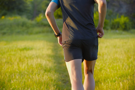 Young man is running on summer meadow - lovely sunset light