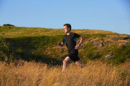 Young man is running in nature - selective focus の写真素材