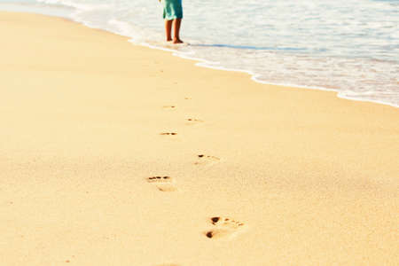 Human footprint in wet sand on the beach - selective focusの写真素材
