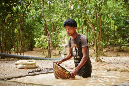 MEETIYAGODA, SRI LANKA - SEPTEMBER 7  The worker is washing the stones extracted from moonstone mine on September 7, 2013 in Meetiyagoda  Moonstone is one of gems found in Sri Lanka のeditorial素材