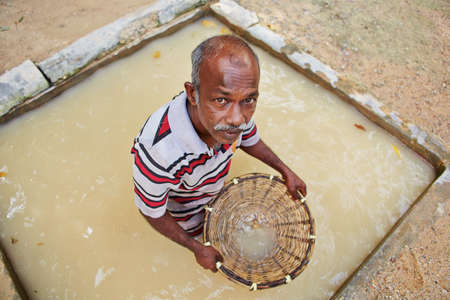 MEETIYAGODA, SRI LANKA - SEPTEMBER 9  The worker is washing the stones extracted from moonstone mine on September 9, 2013 in Meetiyagoda  Moonstone is one of gems found in Sri Lanka のeditorial素材