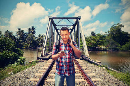 Young traveler with mobil phone in the railwayの写真素材