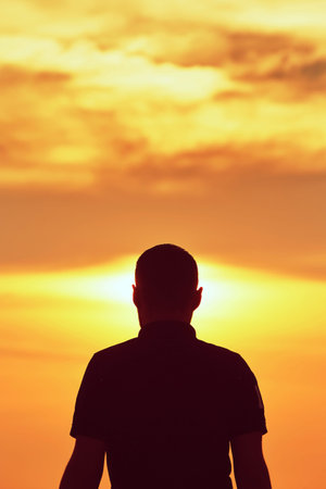 Silhouette of young man at sunset - copy spaceの写真素材