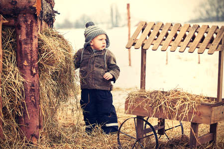 Little boy on the farm in winterの写真素材