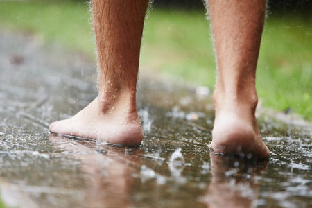 Man without shoes in heavy rain - selective focusの写真素材