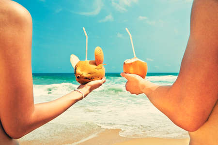 Hands of the couple with coconut drinksの写真素材