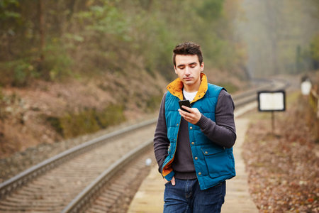 Young man is waiting on the platform rural railway station