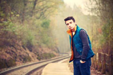 Young man is waiting on the platform rural railway station - retro colorsの写真素材