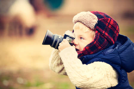 Little boy with camera is shooting in the farmの写真素材