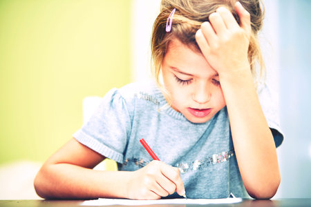 Little girl is doing his homework for elementary school.