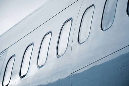Windows of the white airplane - blue tonedの写真素材