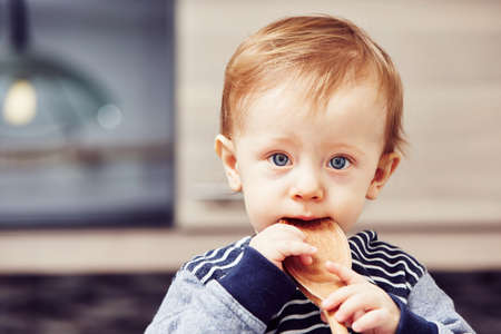 Little chef - boy with wooden spoon in the kitchenの写真素材