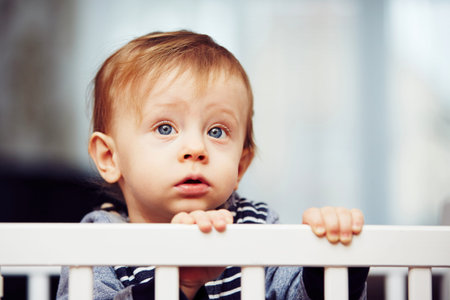 Little boy is waiting in the bedの写真素材