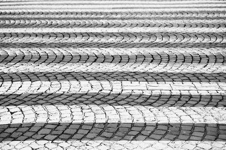 Pedestrian crossing on obsolete cobblestone road pavement.