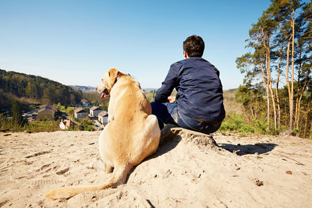Young traveler with his dog on the hill